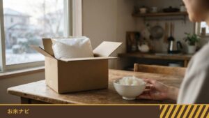 ふるさと納税で届いた段ボール箱の中のお米と、お茶碗に盛ったご飯が窓辺のテーブルに置かれた様子
