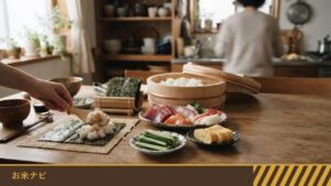 手巻き寿司の準備をしたテーブルで、のりの上に酢飯をのせている手元と、刺身・きゅうり・卵焼きの皿